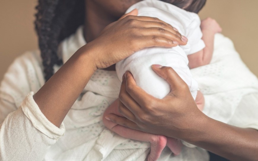 A mother holding a newborn baby, tips for successful postpartum recovery