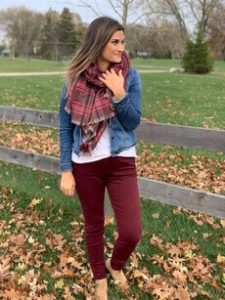 A woman showing how to match burgundy pants and blue jean jacket 