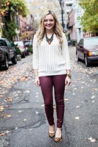 A woman showing how to match burgundy pants and a cream-colored sweater top