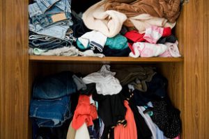 A cluttered closet due to excess clothes